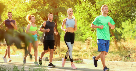 Wall Mural - Group of sporty young people running outdoors