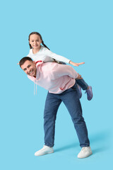 Canvas Print - Father playing with his daughter on blue background