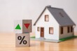 © pla2na - Wooden blocks percentage sign, arrow up and down with house model background. Central bank FED control interest rate increase or decrease effect to house price, monthly payment, buying home concept.