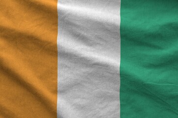 Wall Mural - Ivory Coast flag depicted on folded wavy fabric of old cloth close up