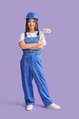 Wall Mural - young female painter with roller on lilac background