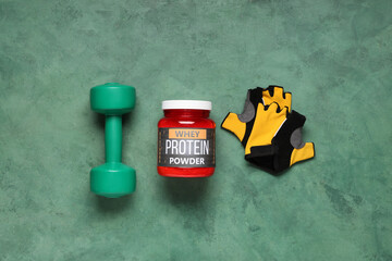 Wall Mural - Bottle of protein powder, dumbbell and bicycle gloves on color background