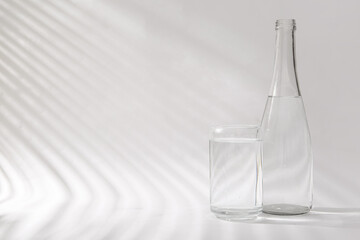 Wall Mural - Bottle of clean water and glass on white background