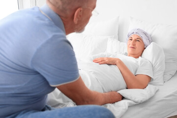 Poster - Mature woman after chemotherapy lying with her husband in bedroom