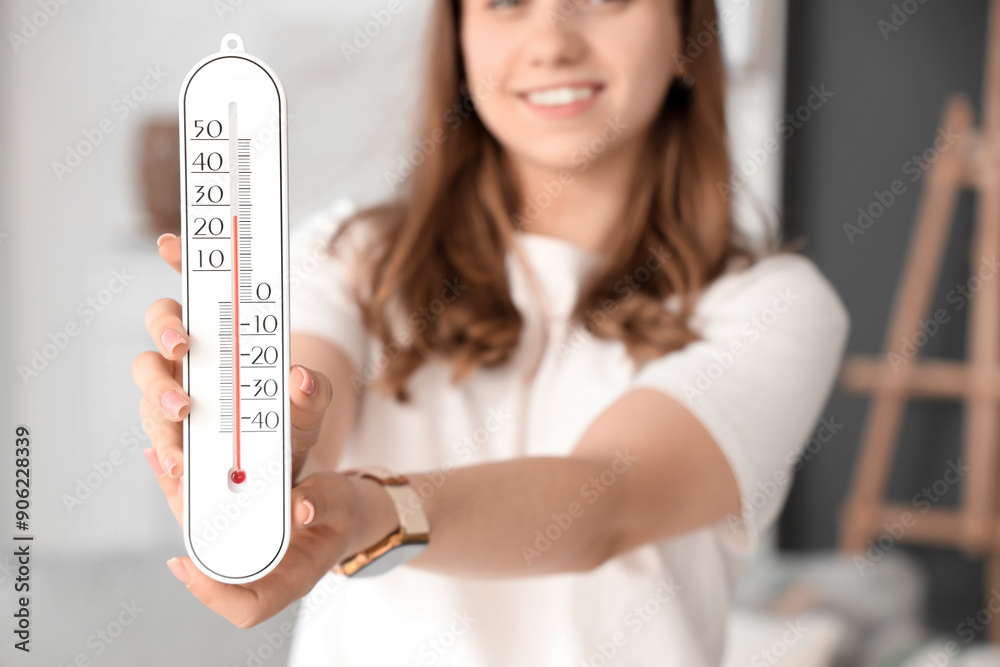 Woman with home thermometer in room, closeup
