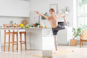 Canvas Print - Sporty young woman training in kitchen