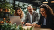 © halo - Team of businesspeople using a laptop in an office, photography.