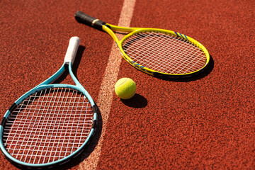 Wall Mural - Close up view of tennis racket and balls on the clay tennis court