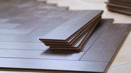 Poster - Laying laminate flooring in a new apartment, the laminate is stacked and laid on the floor. Repair with your own hands.