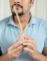 man holds scented aromatic reed diffuser sticks set