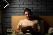© Vitaliy - Tired man reading book in the bed before going to sleep