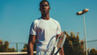 © VK Studio - Tennis player in a white outfit stands confidently on an outdoor court under a clear blue sky.
