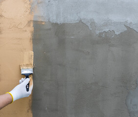 Wall Mural - A person is painting a wall with a brush