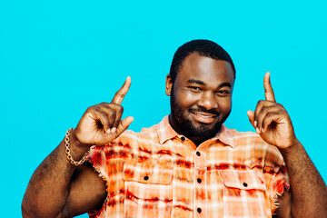 Portrait of a smiling man pointing up, isolated on blue background