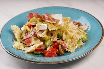 Italian pasta salad cucumbers, cherry tomatoes, olives, red onion,  salami, feta cheese