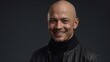 © Heruvim - Bald smiling man in black turtleneck and leather jacket