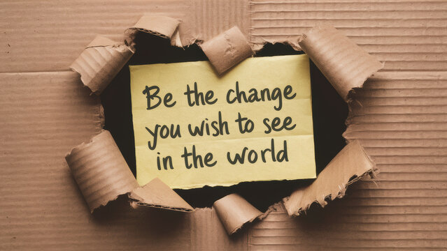 A piece of cardboard with a message taped to it, be the change you wish to see in the world, AI