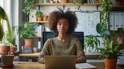 Poster - A woman sits at a desk in a home office, working on a laptop computer. There are several potted plants in the room, creating a natural and relaxing atmosphere.