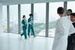 © DragonImages - Group of doctors walking along the corridor in clinic