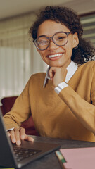 Wall Mural - Smiling female manager working remotely on laptop from home and looks at camera