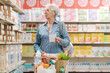 © StockPhotoPro - Confused elderly woman buying groceries at the supermarket