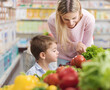 © StockPhotoPro - Mother showing healthy vegetables to her son at the supermarket