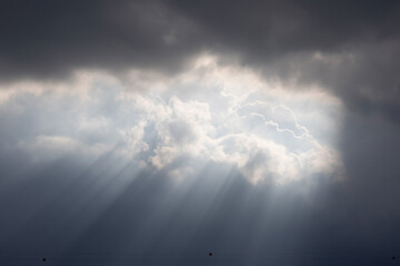 Wall Mural - The sky is cloudy and the sun is shining through the clouds