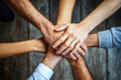 © pilipphoto - Business and teamwork concept - diverse team putting their hands together