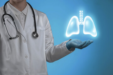 Wall Mural - Doctor holding virtual lungs on light blue background, closeup