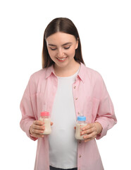 Poster - Expecting twins. Pregnant woman holding two bottles with milk on white background