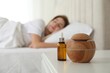 © New Africa - Woman sleeping at home, focus on aroma diffuser and essential oil