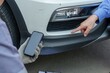 © Ekkasit A Siam - Close-up of insurance officer holding smartphone near car bumper, capturing damage details while client points at scratches. precise documentation during vehicle inspection for insurance claim.