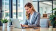 © Suchithra - A confident businesswoman sitting in a bright office, smiling as she completes her work on a laptop, representing professionalism, modern technology, and workplace satisfaction.