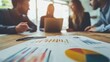 © Chano_1_na - A focused business meeting with professionals analyzing charts and graphs to discuss performance and strategies in a modern office.