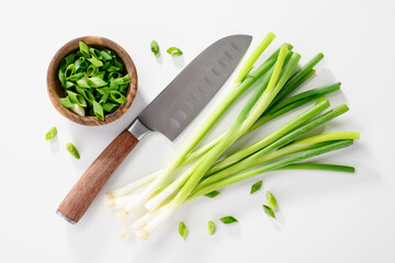 Cut fresh green onions with knife on white background