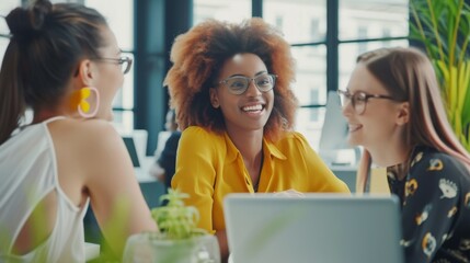 Wall Mural - Happy female coworkers collaborating and working together at a desk in a modern office