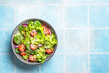 Wall Mural - Green vegetable salad with fresh leaves on white plate. Healthy food, diet menu. Top view with space for text.