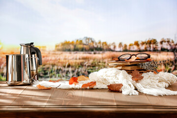 Wall Mural - Autumn composition of white scarf and book and coffee and autumn leaves on wooden table with copy space for products. Autumn season landscape background.