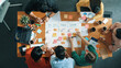 © Summit Art Creations - Top down aerial view of business team making scrum task board at meeting room. Group of people writing at paper and sticky notes for making kanban board to manage work flow. Top view. Convocation.