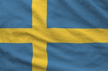 Wall Mural - Sweden flag depicted on folded wavy fabric of old cloth close up