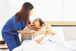 © ฺฺฺBoonterm - Female doctor nurse take care elderly female patient who is being treated for discomfort due congenital disease gently supporting her shoulder to help her sleep : Elderly health insurance.