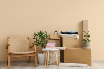 Wall Mural - Furniture, houseplants and cardboard boxes with belongings near beige wall. Moving house concept