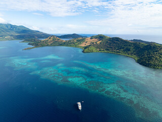 Sticker - A beautiful coral reef surrounds the volcanic island of Pulau Pura in Indonesia. This scenic area is near Maumere, Flores, and is home to extraordinary marine biodiversity.