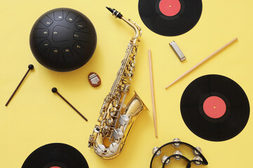 Wall Mural - Different musical instruments and vinyl disks on yellow background