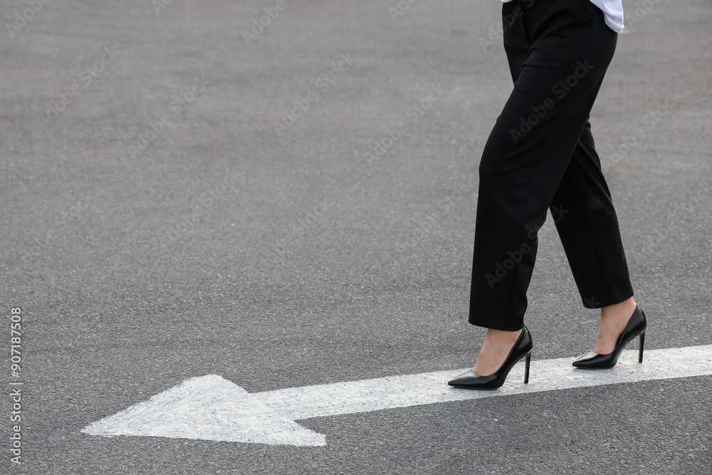Businesswoman going along road with arrow marking. Concept of career choice