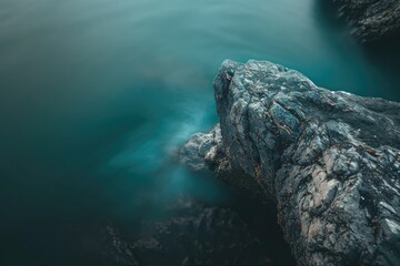 Poster - A solitary rock sits in the center of a calm lake or sea
