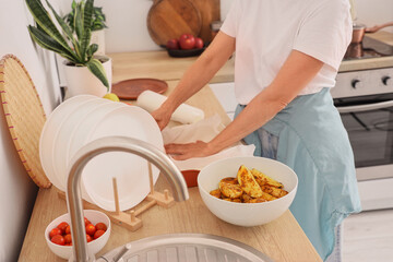 Canvas Print - Female food blogger putting baking paper onto dish while recording cooking video class in kitchen, closeup