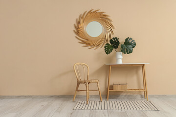 Wall Mural - Chair, mirror and vase with monstera leaves on table near beige wall