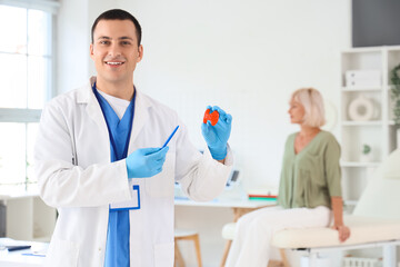 Poster - Male endocrinologist with thyroid gland model in clinic