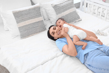 Canvas Print - Happy mother with her little baby lying in bedroom